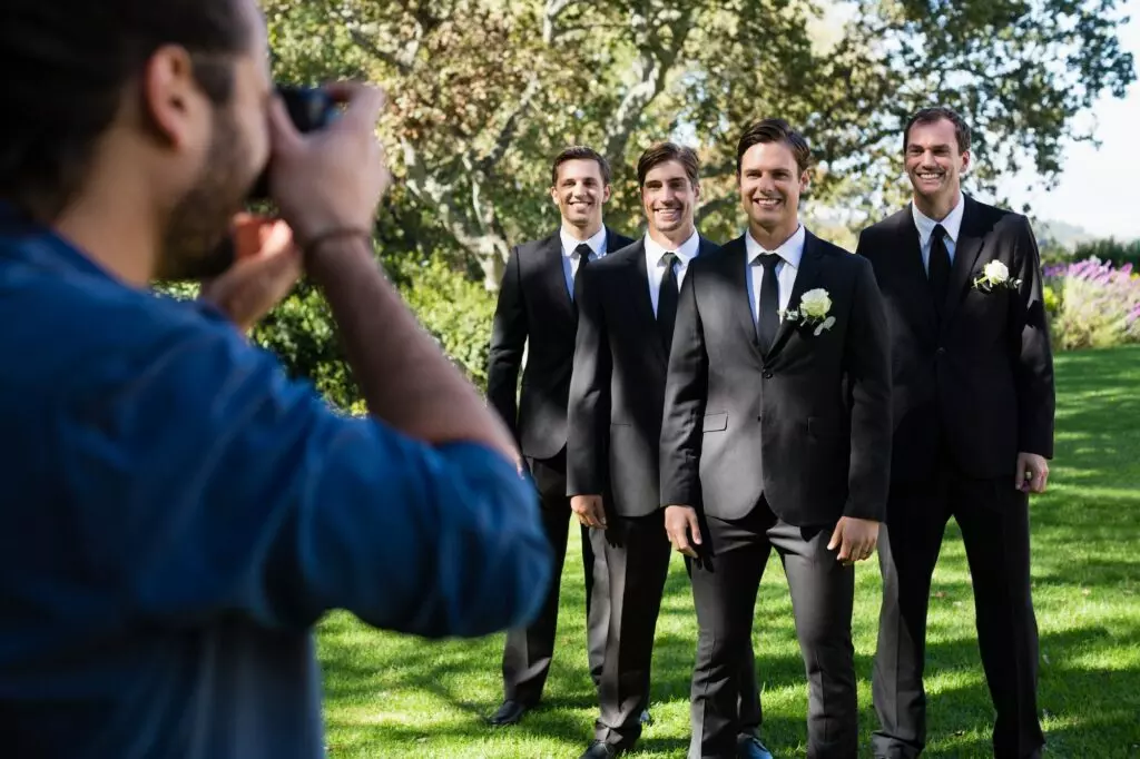 Photographer taking photo of groom and groomsmen